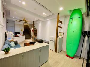 a living room with a green surfboard on the wall at Seyan Inn in Eluan
