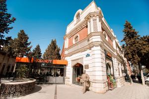 a building with a man standing in front of it at Cinema Boutique Hotel in Ganja