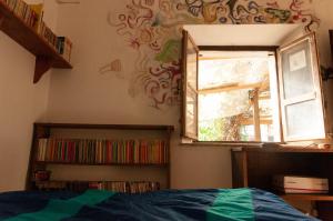 1 dormitorio con ventana y estante para libros en Centro Studi Nuovarmonia, en Cedri