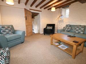 a living room with two couches and a coffee table at Kings Cottage in Grantham