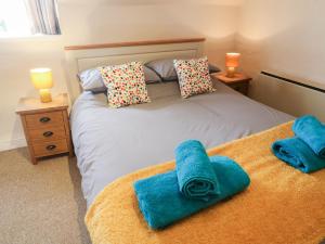 a bedroom with a bed with blue towels on it at Kings Cottage in Grantham