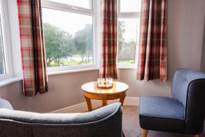 a living room with two chairs and a table and a window at HK Rooms - Self Catering Rooms in Lowestoft