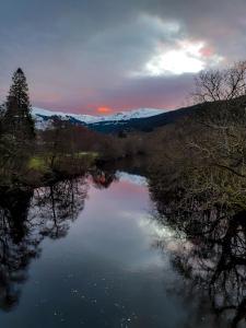 a view of a river with trees and a sunset at The White Stag Inn in Strathyre