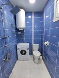a blue tiled bathroom with a toilet and a washing machine at Hotel Best Apart in Istanbul +24 photos