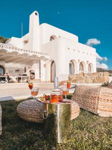 een wit huis met een tafel met wijnglazen erop bij Villa Buen Retiro in Zahara de los Atunes