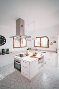 uma cozinha com armários brancos e um forno com placa de fogão em Villa Buen Retiro em Zahara de los Atunes