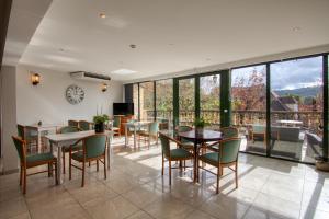 a dining room with tables and chairs and windows at Hôtel Restaurant Plaisance-Piscine couverte et chauffée- Proche Sarlat- in Vitrac