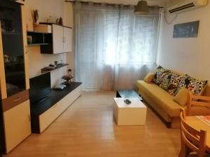 een woonkamer met een gele bank en een tafel bij Apartment Lili in Blagoevgrad