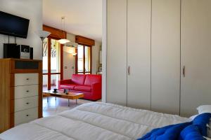 a bedroom with a bed and a red couch at UR-NEST Emilia Levante B in Bologna