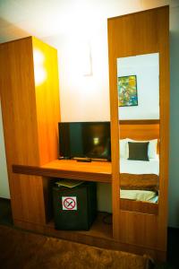 コスティネシュティにあるHotel Regalの鏡、ベッド、テレビが備わる客室です。