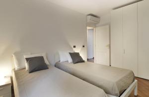deux lits dans une chambre aux murs blancs dans l'établissement UR-NEST Moline, à Bologne