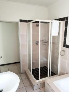 a shower with a glass door in a bathroom at NST City Apartments @ 9 Joubert in Nelspruit