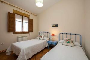 una camera da letto con due letti, un tavolo e una finestra di CASA ERNESTO Piscina Climatizada, porche y garaje a Zamora Altre 39 foto