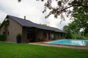 a house with a swimming pool in front of it at Thaba Pitsi Safari Lodge in Bela-Bela