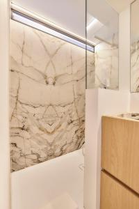 a bathroom with a marble wall at Suite Riverside in Nieuwpoort +19 photos