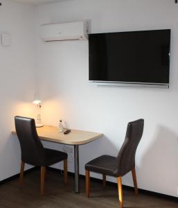 um quarto com uma mesa e duas cadeiras e uma televisão em HRC Pfeffermühle em Landstuhl