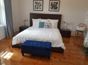 a bedroom with a large bed with a blue ottoman at Semaphore Sea Breeze-Family Beach-Heated Plunge Pool Holiday House 4 brm 2 bath in Semaphore