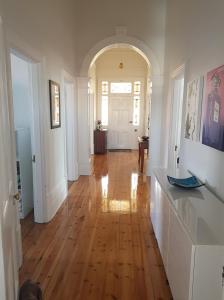 a hallway of a home with a wooden floor at Semaphore Sea Breeze-Family Beach-Heated Plunge Pool Holiday House 4 brm 2 bath in Semaphore