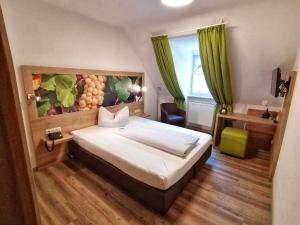 Un dormitorio con una cama con un cuadro en la pared. en Gasthof Hotel Weinbau "Zum Goldenen Ochsen", en Sommerhausen