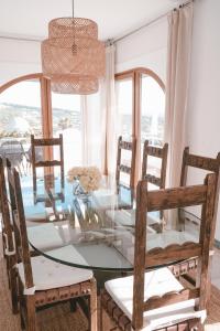 a dining room with a glass table and chairs at Villa Buen Retiro in Zahara de los Atunes