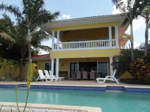 a villa with a swimming pool and a house at Kas na Nort in Willemstad