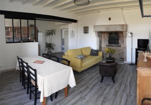 - un salon avec une table et un canapé jaune dans l'établissement Gîte de La Ribotière à 15 min du Puy du Fou, à Pouzauges