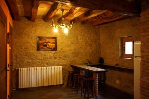 a kitchen with a bar in a stone wall at 6 bedrooms villa with private pool and wifi at Llobera in Llanera