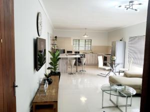 uma sala de estar e cozinha com um sofá e uma mesa em NST City Apartments @ Casalinga Villa em Nelspruit