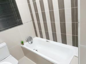 a bathroom with a bath tub and a toilet at NST City Apartments @ Casalinga Villa in Nelspruit