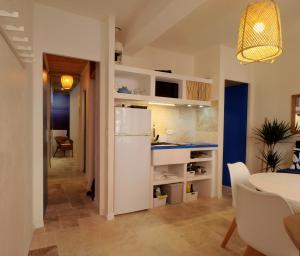 a kitchen and dining room with a white refrigerator at Les Petites Cyclades in Biarritz