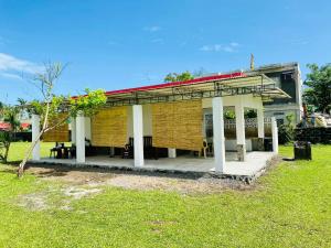 a small building with a roof on a grass field at Viento de Mar in Gindi