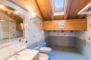a bathroom with a toilet and a sink and a window at Zenith - Casa Azzurra Mansarda in Livigno +13 photos