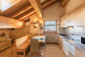 a kitchen and dining room with a table and a couch at Zenith - Casa Azzurra Mansarda in Livigno