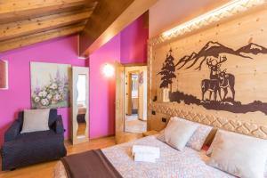 a bedroom with purple walls and a bed and a chair at Zenith - Casa Azzurra Mansarda in Livigno
