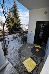 un patio con mesa y sillas en la nieve en FLORI'S Apartment en Brasov