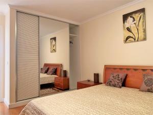 a bedroom with two beds and a large mirror at Charming Calheta Plaza Penthouse in Calheta