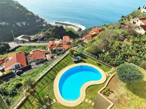 an aerial view of a resort with a swimming pool and the ocean at Charming Calheta Plaza Penthouse in Calheta