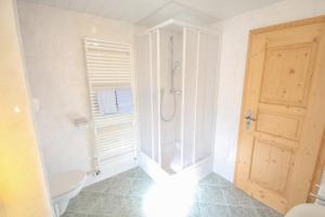 a bathroom with a shower and a toilet and a door at Ferienwohnung Graßl in Schönau am Königssee