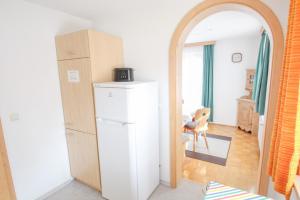 a room with a white refrigerator and a mirror at Ferienwohnung Graßl in Schönau am Königssee