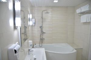 a bathroom with a shower and a toilet and a sink at Hotel Požega in Požega