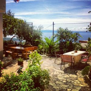 a patio with a table and a bench and the ocean at Apartments Panorama in Makarska