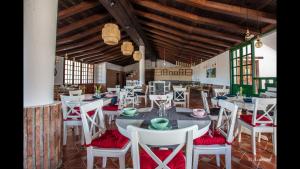ein Esszimmer mit weißen Tischen und roten Stühlen in der Unterkunft Room in Bungalow - Bungalow Double 19 - El Cortijo Chefchaeun Hotel Spa in Chefchaouen