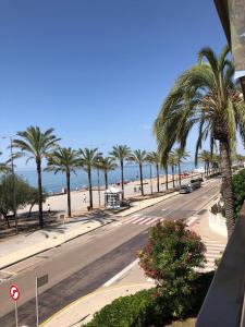 una calle vacía con palmeras y una playa en Face à La Mer, en Calafell