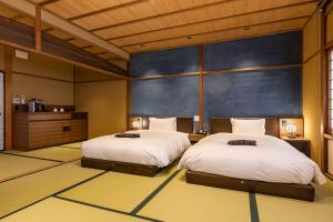 a bedroom with two beds and a blue wall at 祇園の宿 杏花 in Kyoto