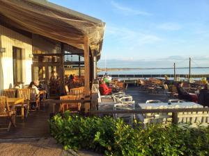 people sitting on the deck of a restaurant at Kapitänshaus in Ueckeritz