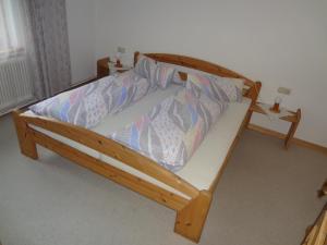 a bed in a room with a wooden frame at Haus Sonnegg in Fieberbrunn