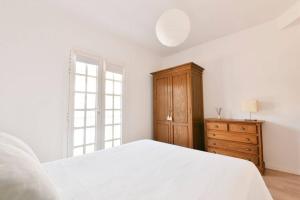 1 dormitorio con cama blanca y tocador de madera en VV El Tonolero, en Breña Baja 21 fotos más