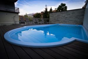 een zwembad op een terras met stoelen eromheen bij Residence Alle Palme in Riva del Garda