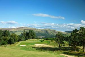 a view of a golf course with mountains in the background at The Gleneagles Hotel in Auchterarder