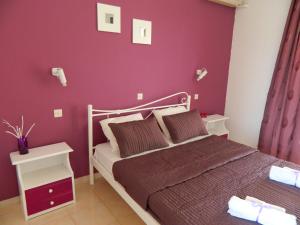 um quarto com uma cama com uma parede vermelha em Roseberry Studios em Faliraki